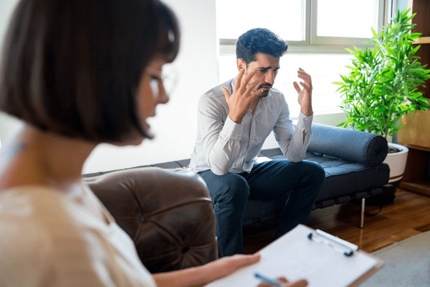Therapy session with distressed male patient.